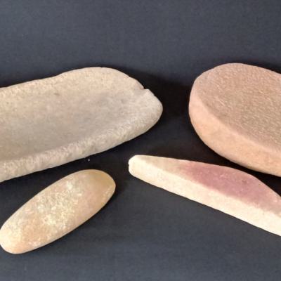 Two Neolithic grindstones, 35 and 46 cm. long with extra tools, used to grind wheat or maize or to grind hematite for its ocre colour. Northern-Mali/Sahara.