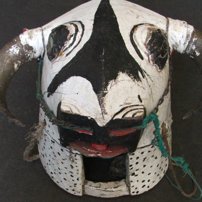 Buffalo helmet-mask, with buffalo-horns, rope, glass, iron and paint. H. 33 cm. Bidjogo. Guinée Bissau. On steel socle.